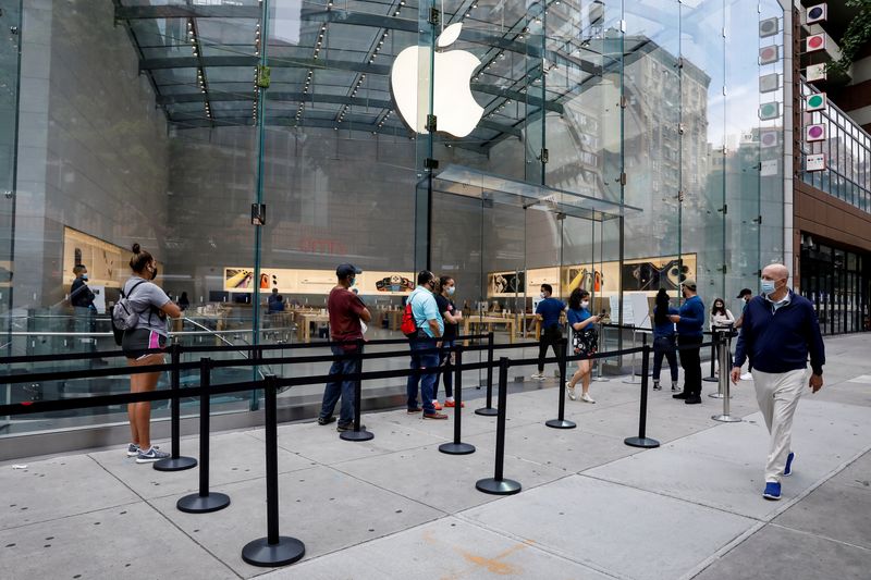 FILE PHOTO: Customers distance before entering an Apple Store during
