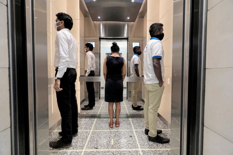 FILE PHOTO: People practice social distancing inside an elevator at
