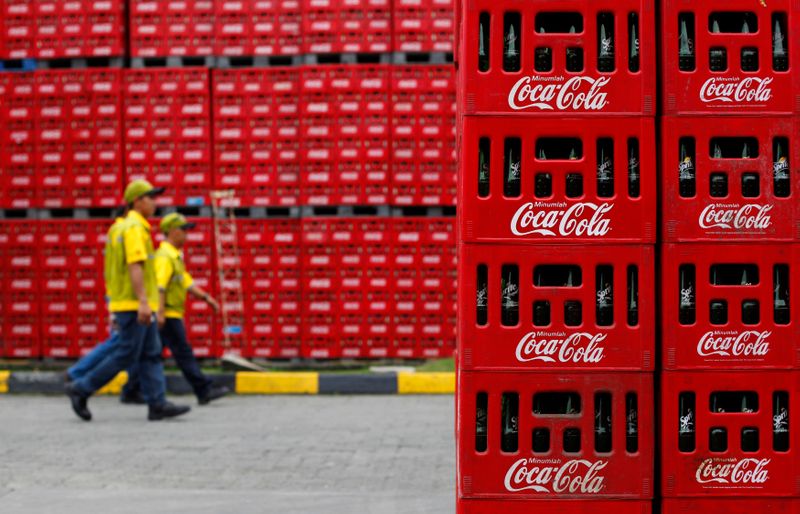 FILE PHOTO: Workers walk at PT Coca-Cola Amatil Indonesia’s factory
