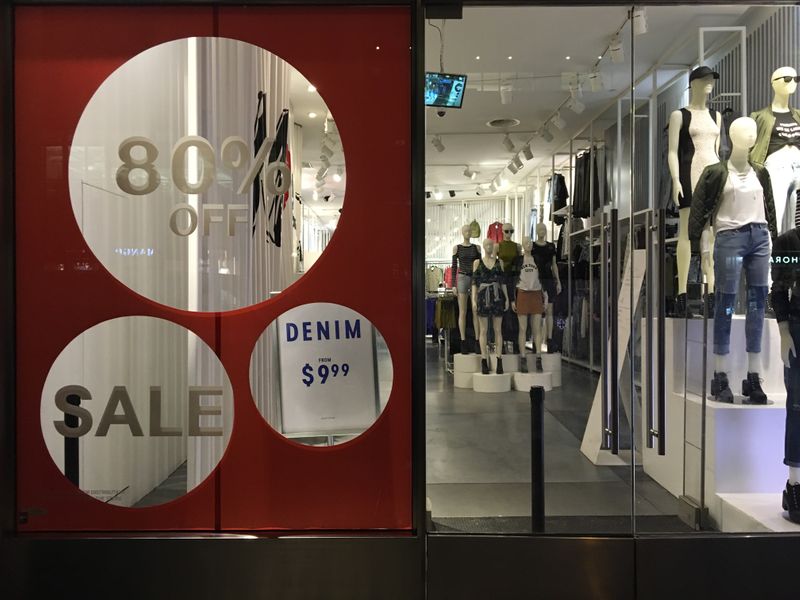 An H&M store has sale signs in the window in