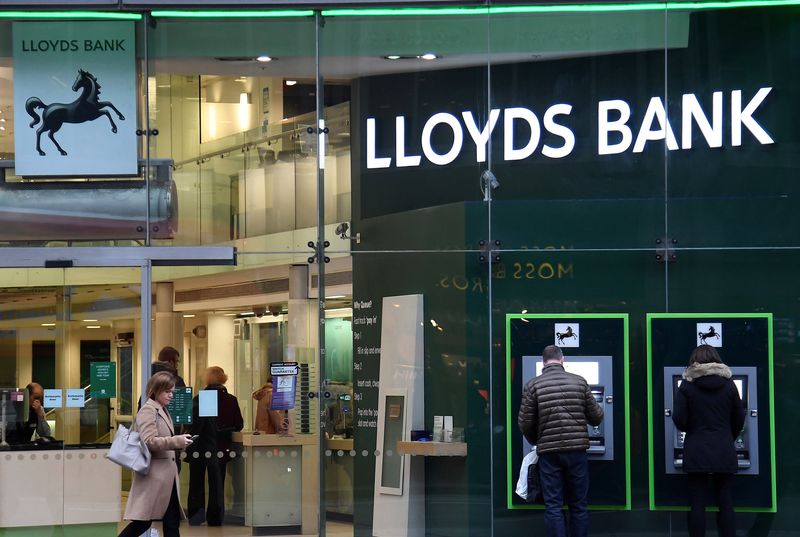 FILE PHOTO: Customers use ATMs at a branch of Lloyds
