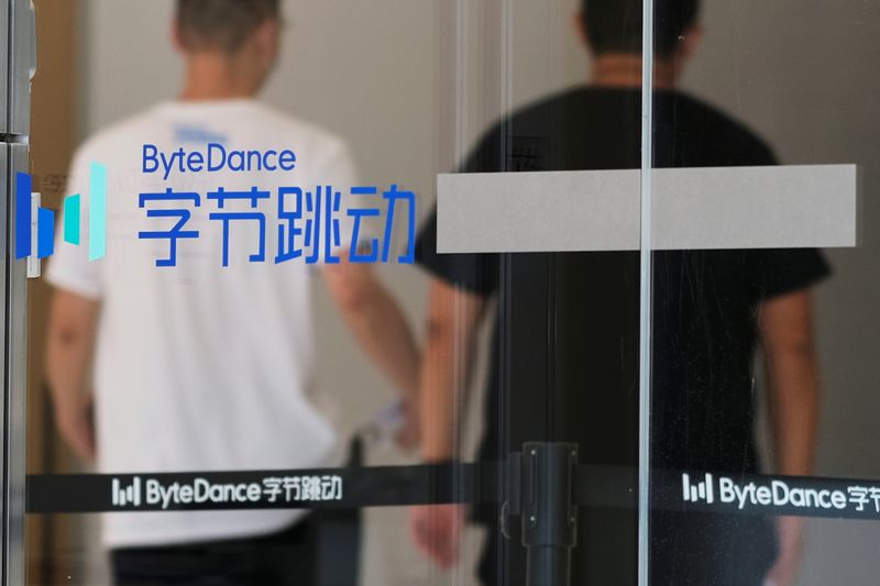People walk past a logo of Bytedance, which owns short