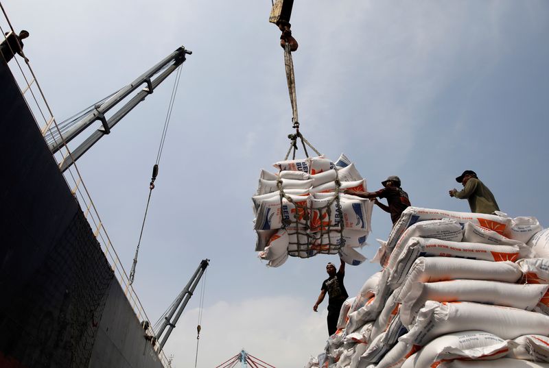FILE PHOTO: Workers unload bags of rice from a cargo