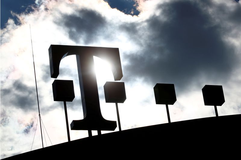 FILE PHOTO: Logo of Deutsche Telekom AG is silhouetted atop