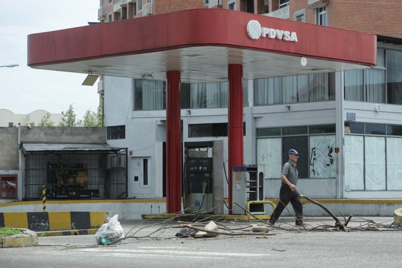 FILE PHOTO: A man walks past a closed gas station