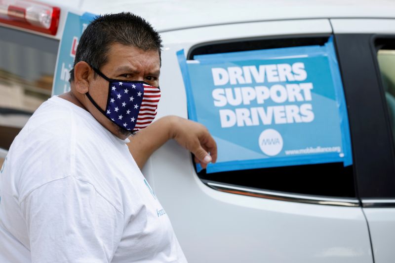 FILE PHOTO: Uber and Lyft drivers demonstrate over basic employee