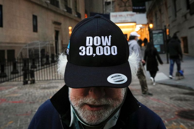 Trader Peter Tuchman wears a DOW 30,000 hat as he
