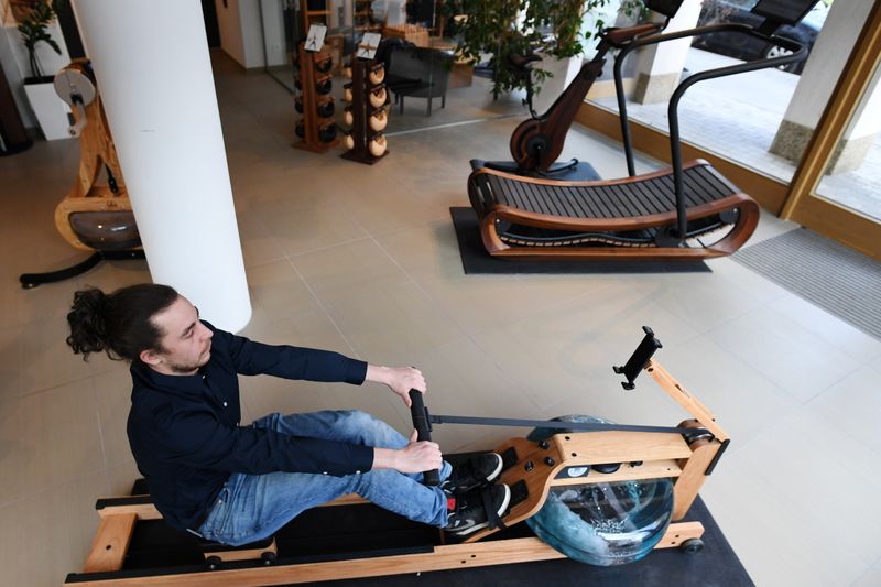 A man tries out a rowing machine in a showroom