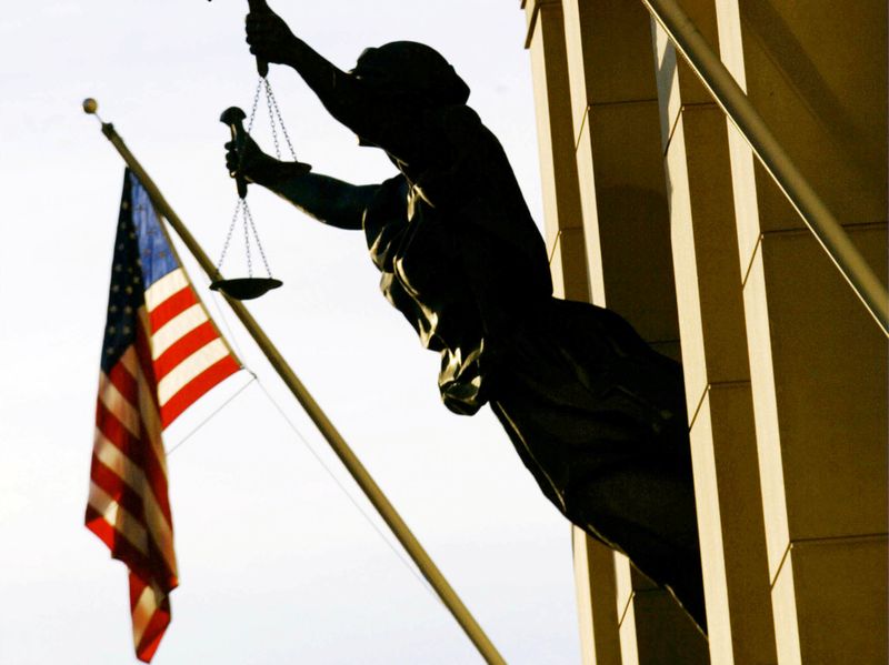 FILE PHOTO: THE AMERICAN FLAG FLIES NEXT TO A STATUE