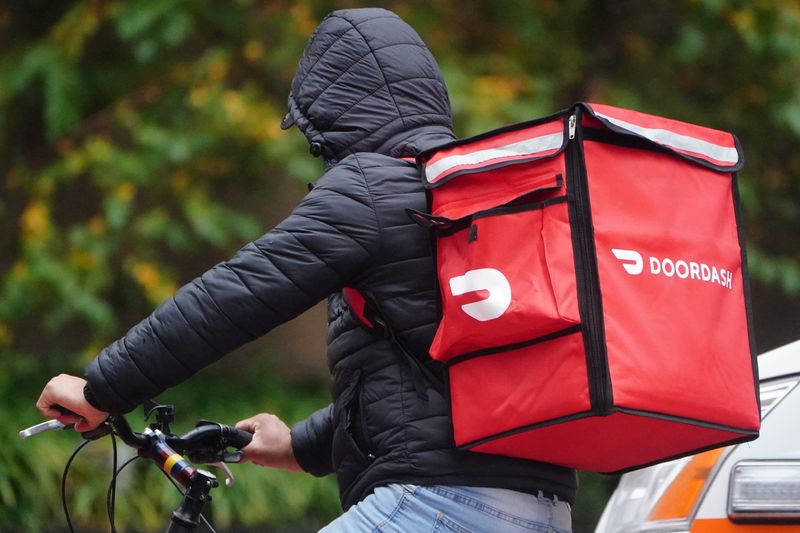 FILE PHOTO: A delivery person for Doordash rides his bike