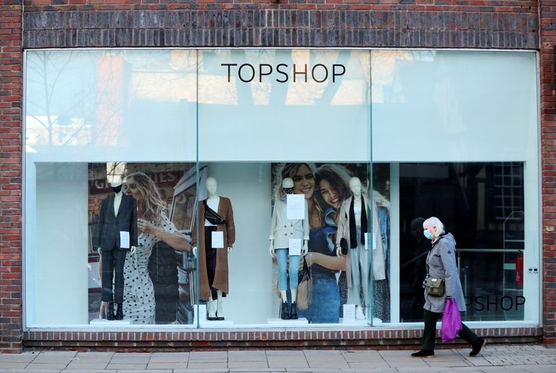 FILE PHOTO: A woman walks past a TopShop, as the