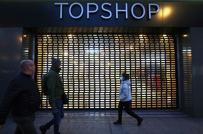 Pedestrians walk past a Topshop store, owed by Arcadia group