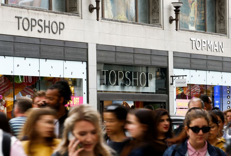 FILE PHOTO: People walk past a Topshop and Topman store,