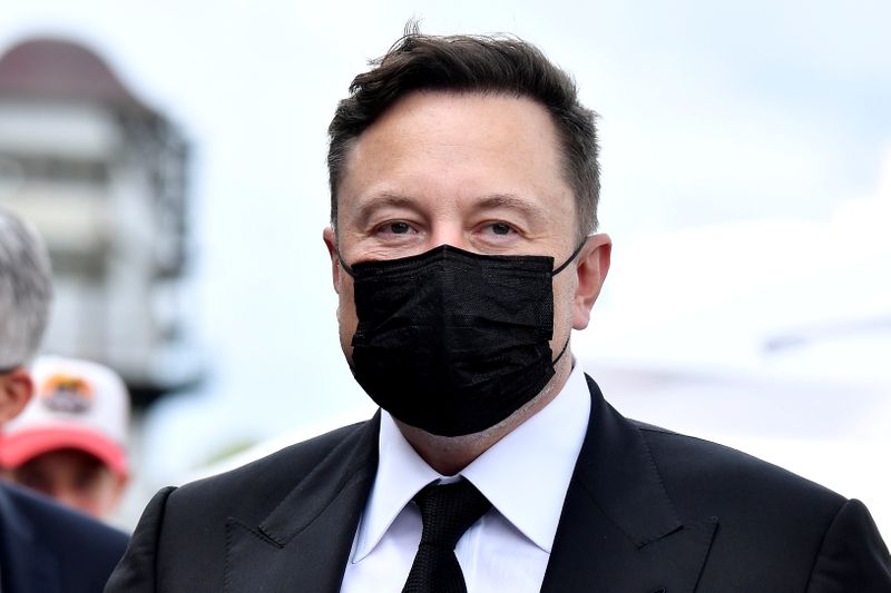 FILE PHOTO: Elon Musk wears a protective mask as he