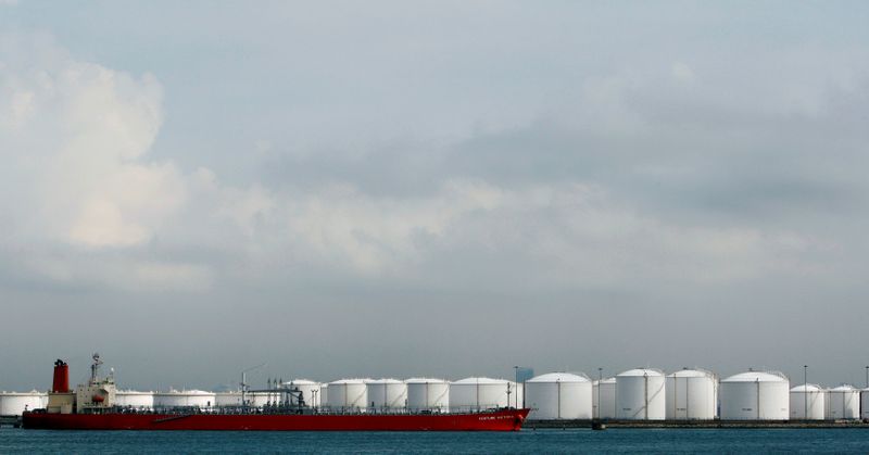 FILE PHOTO: Ship is moored near storage tanks at oil