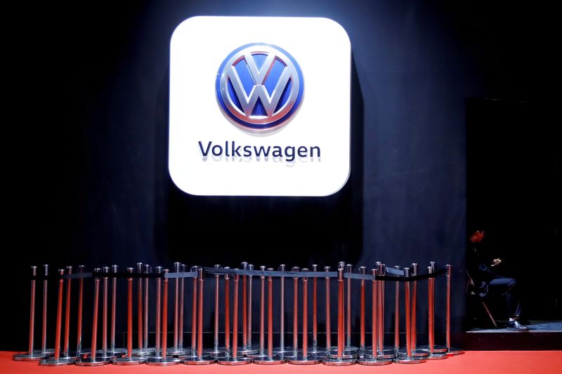 FILE PHOTO: Man uses phone under VW logo at the