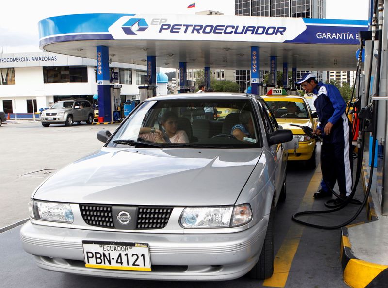 FILE PHOTO: A worker pumps fuel into a car at