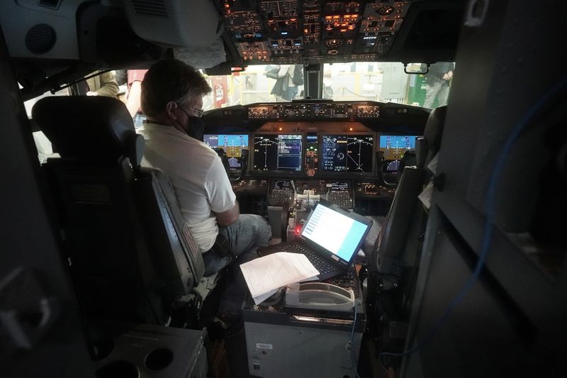 A worker loads new software into the Boeing 737 Max