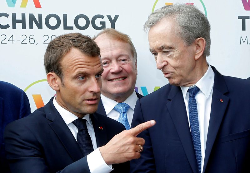 FILE PHOTO: French President Emmanuel Macron talks with LVMH luxury