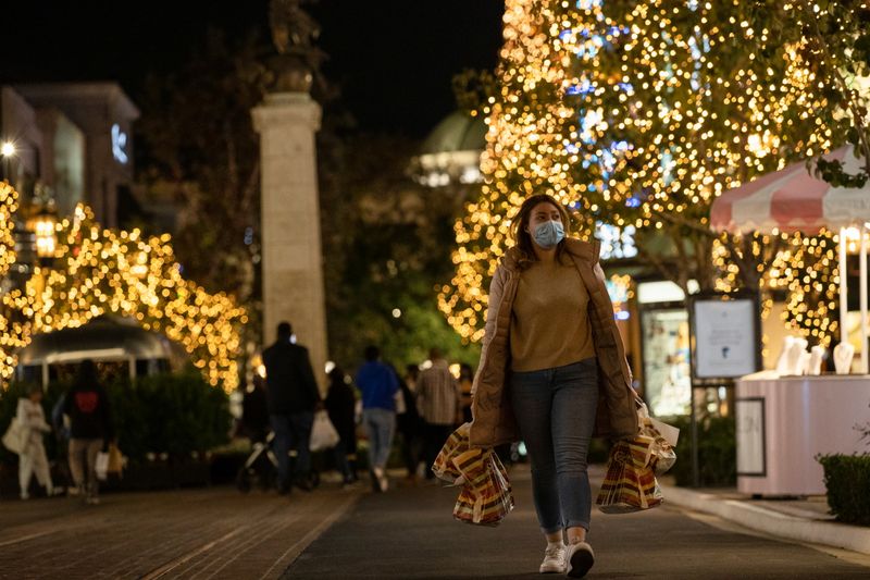 A shopper wearing a face protective mask walks by Christmas