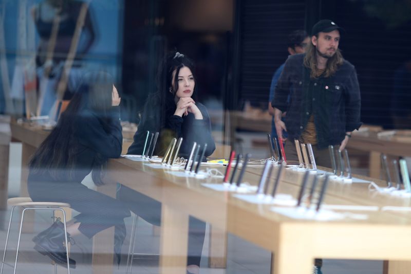 People sit inside a closed Apple Store during the global