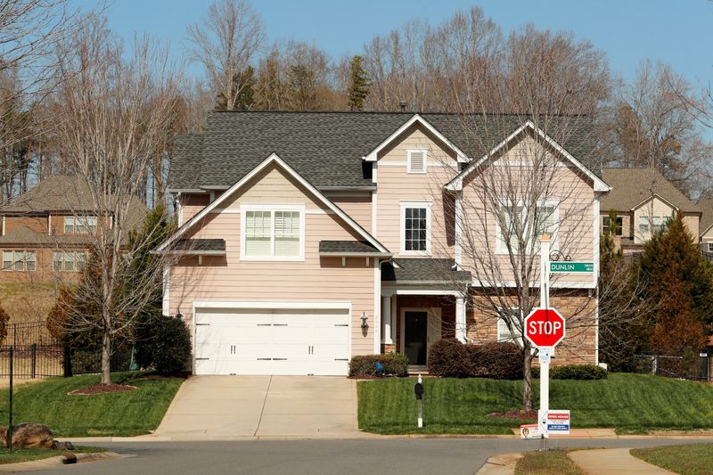 A home stands behind a real estate sign in a