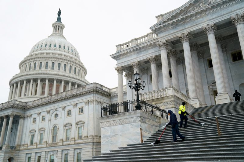 FILE PHOTO: Workers shovel snow from the steps of the