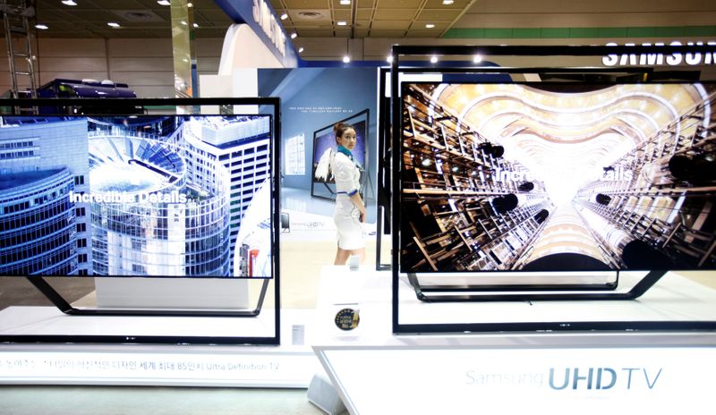 FILE PHOTO: A model stands between Samsung Electronics’ Ultra HD