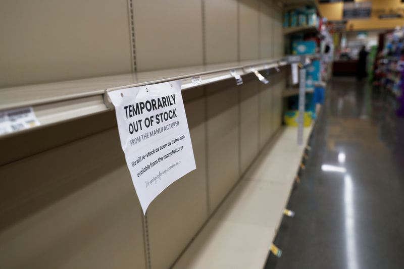A sign hangs from empty shelves, prior to California’s Governor