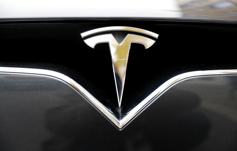 The company logo is pictured on a Tesla Model X