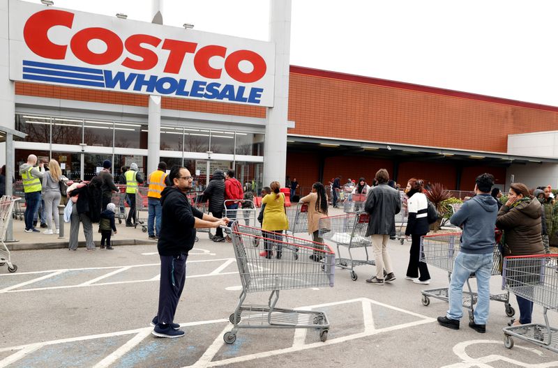 Customers queue to enter a Costco Wholesalers in Chingford, Britain