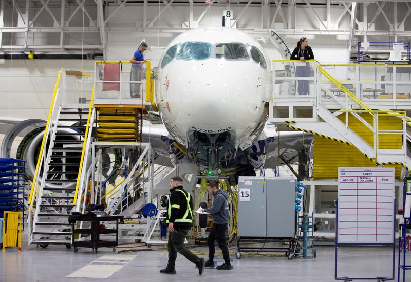 FILE PHOTO: Employees work on an Airbus A220-300 at their