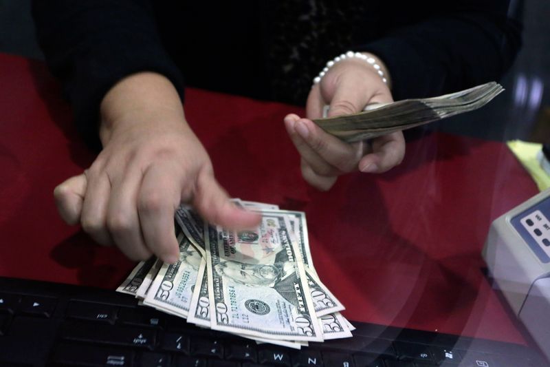 Employee counts U.S. dollar banknotes at a foreign exchange house