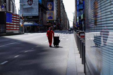 Street sweeper walks through nearly empty Times Square during the