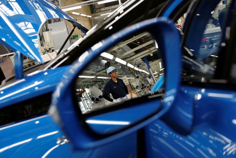 Employees of Toyota Motor Corp. work on assembly line in