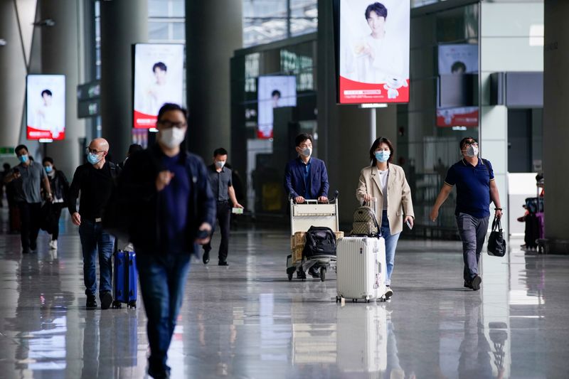 FILE PHOTO: People wearing face masks are seen at Hongqiao
