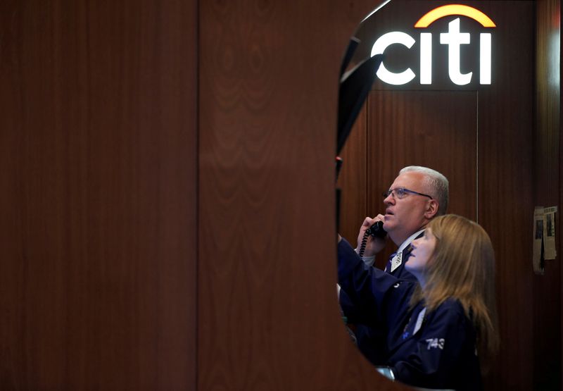 FILE PHOTO: Traders work in the Citigroup booth on the