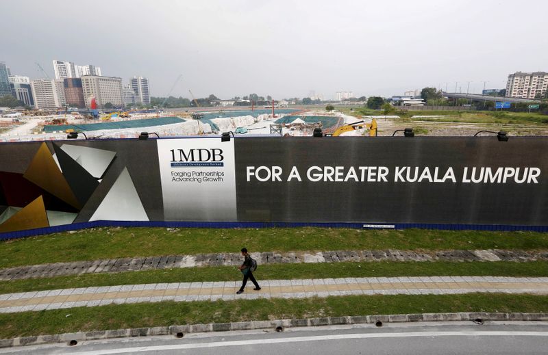 A man walks past a 1 Malaysia Development Berhad (1MDB)
