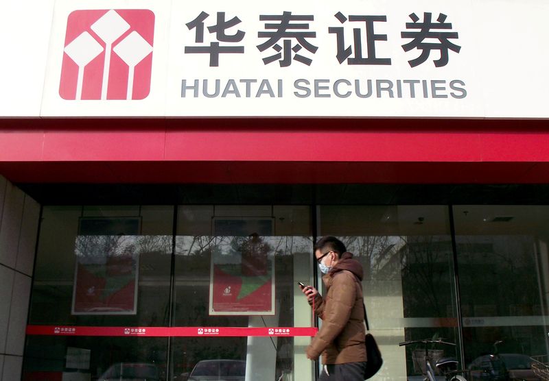 FILE PHOTO: Man walks past a branch of Chinese brokerage