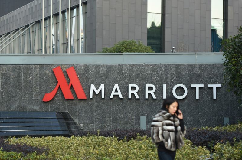 Woman on a mobile phone walks past a Marriott hotel