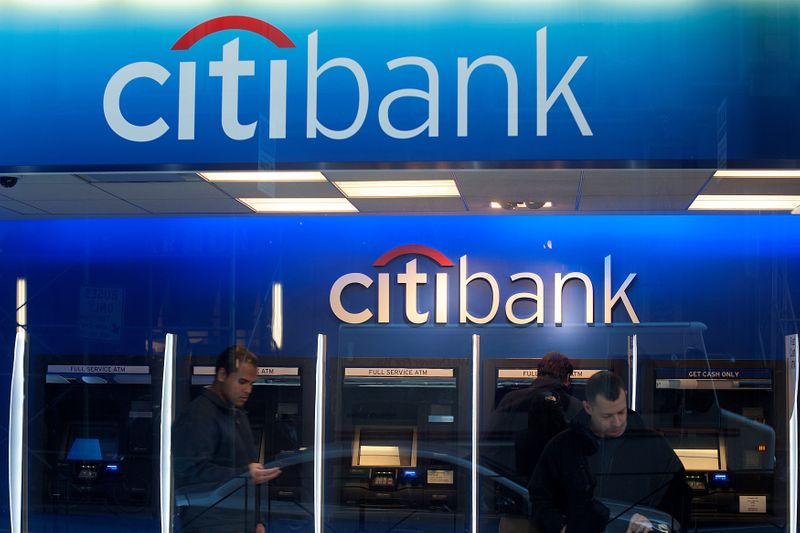 FILE PHOTO: Customers wait at an ATM at a Citibank