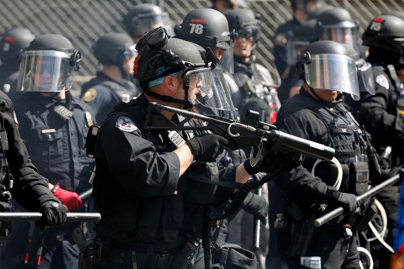 FILE PHOTO: A police officer holds a weapon during nationwide