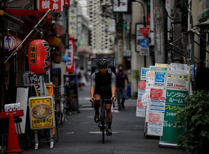 Takenobu Tonegawa cycles as he works his part-time job as