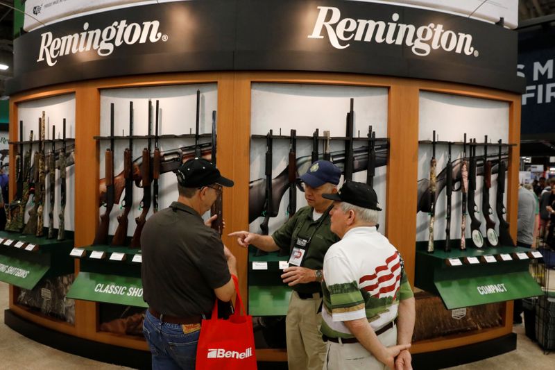 Gun enthusiasts inspect Remington shotguns during the annual National Rifle