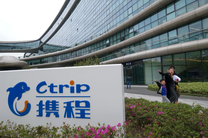 People walk by the logo of online travel firm Ctrip.Com