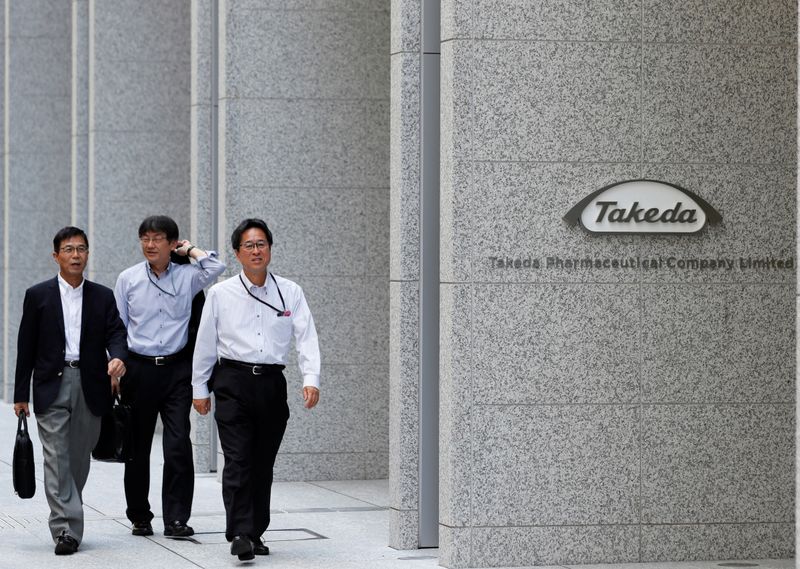 People walk past the new headquarters of Takeda Pharmaceutical Co
