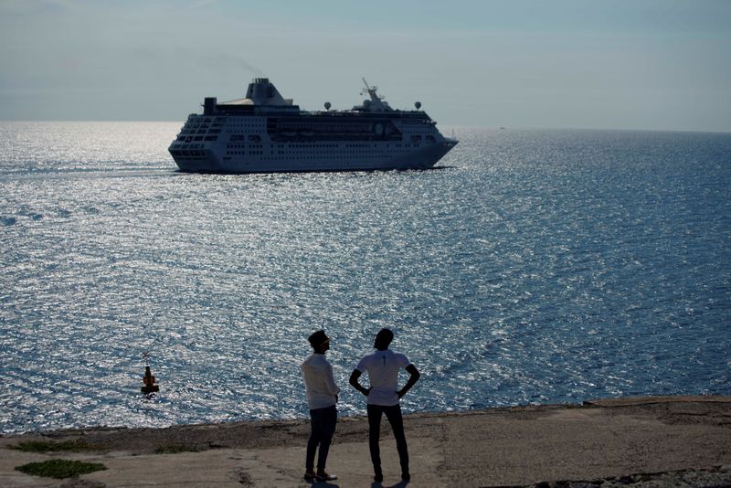 FILE PHOTO: Men watch the cruise ship MS Empress of