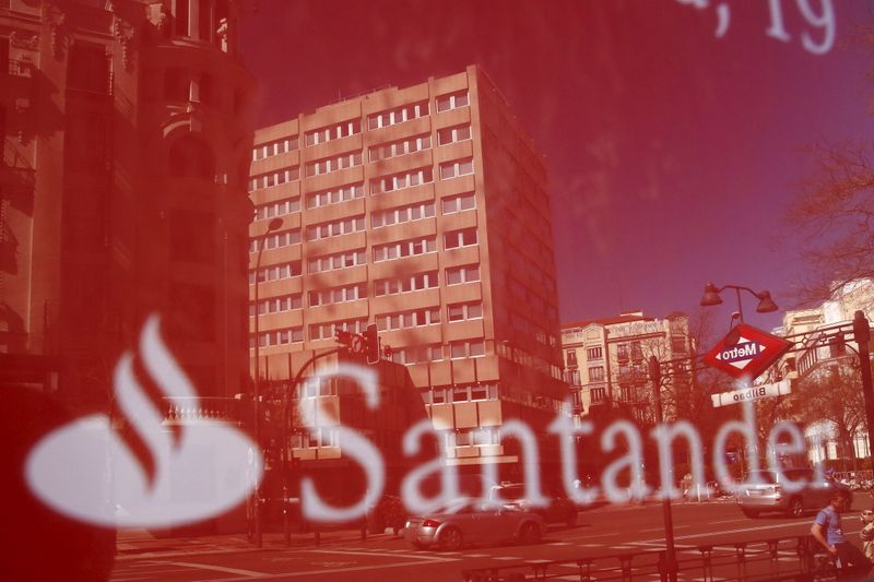 Buildings are reflect on a logo of a Santander bank