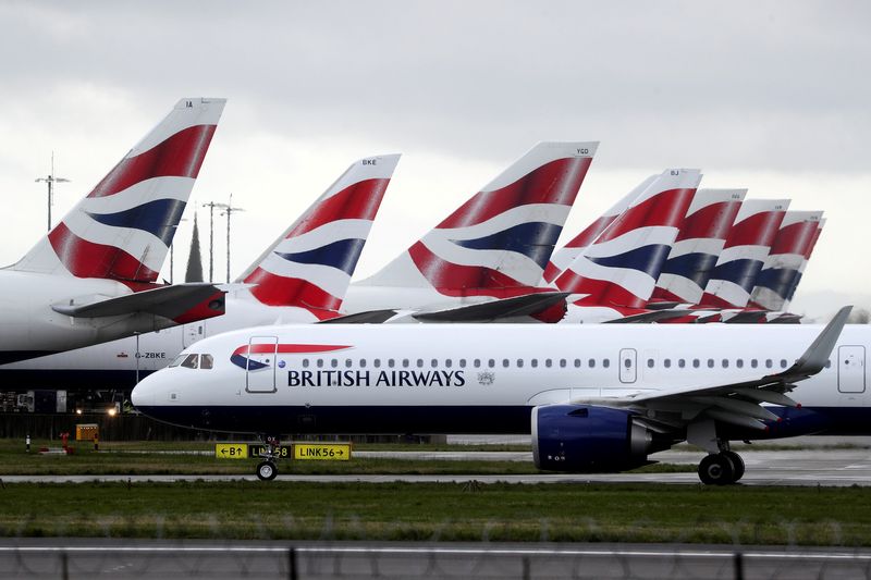FILE PHOTO: A BA plane taxis past parked aircraft near