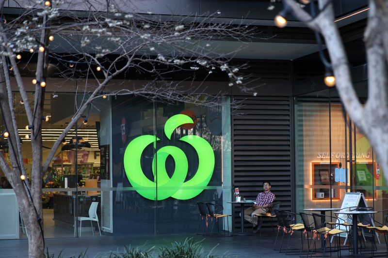 A man sits outside a Woolworths supermarket in Sydney